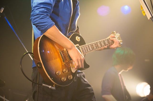 ステージ上でギターを弾く男性